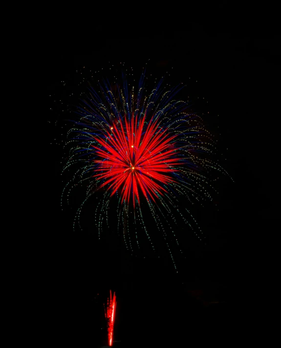 bright red fireworks display above a dark black sky