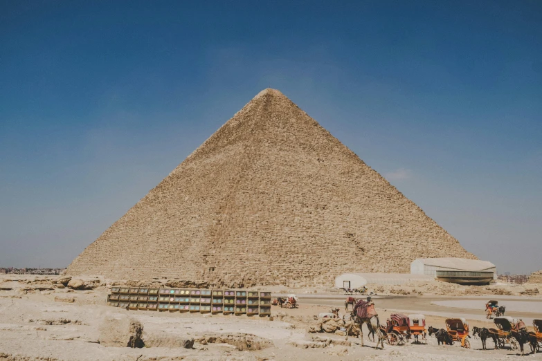 people in their camels are gathered around the pyramid
