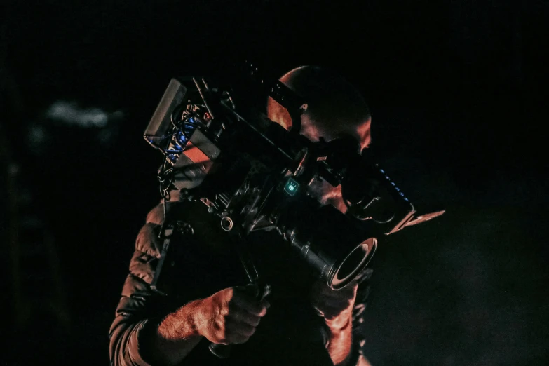 a man is holding a camera in the dark