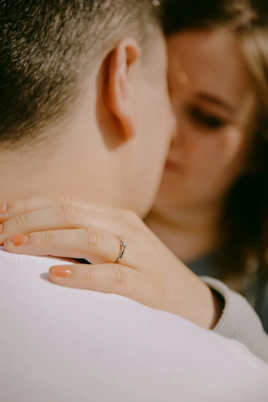 a man kissing a women on the cheek with his hands covering her face