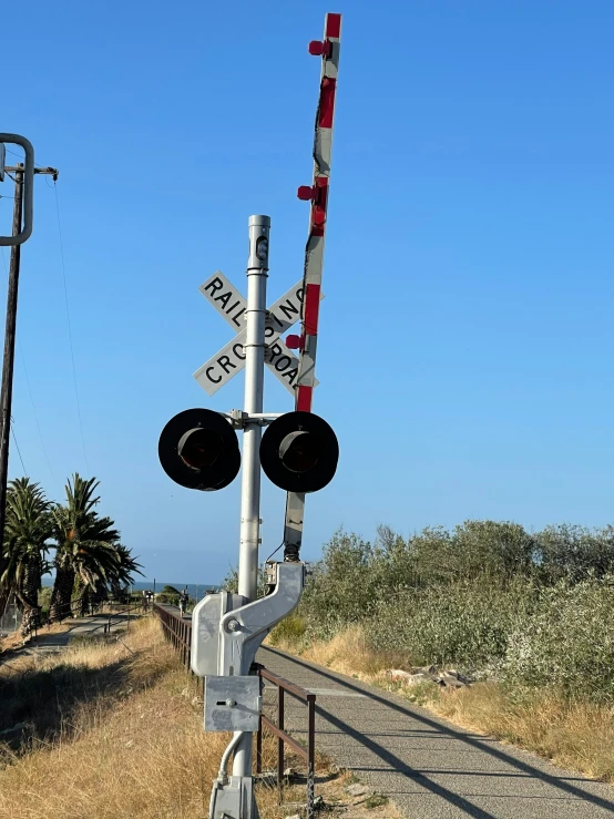 railroad crossing signal with train tracks and sky