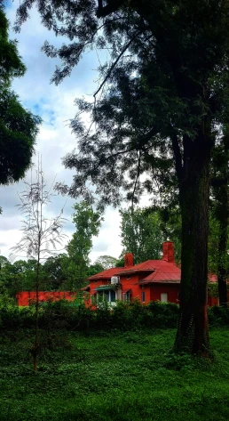 an old red building in a small forest area