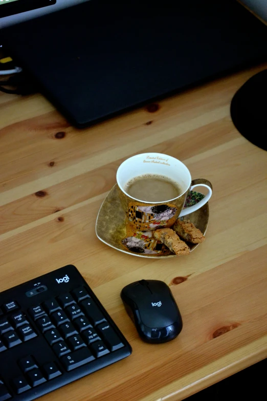 there is a cup of coffee next to a keyboard and mouse