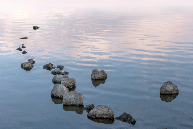 rocks in the water with sky in background