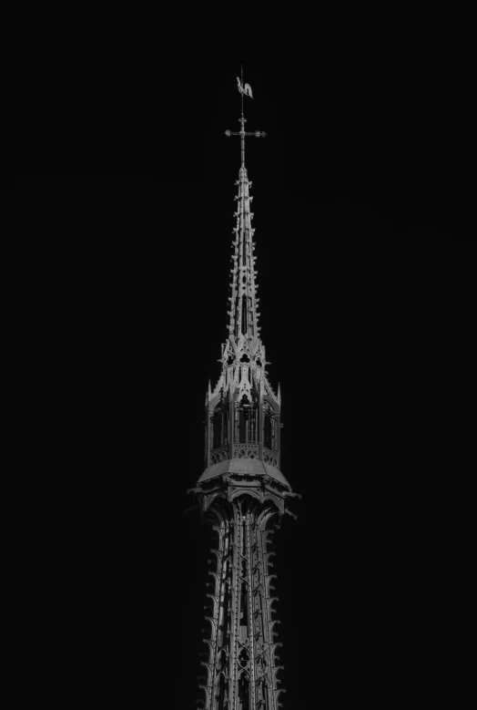 an illuminated white spire with a steeple in the background