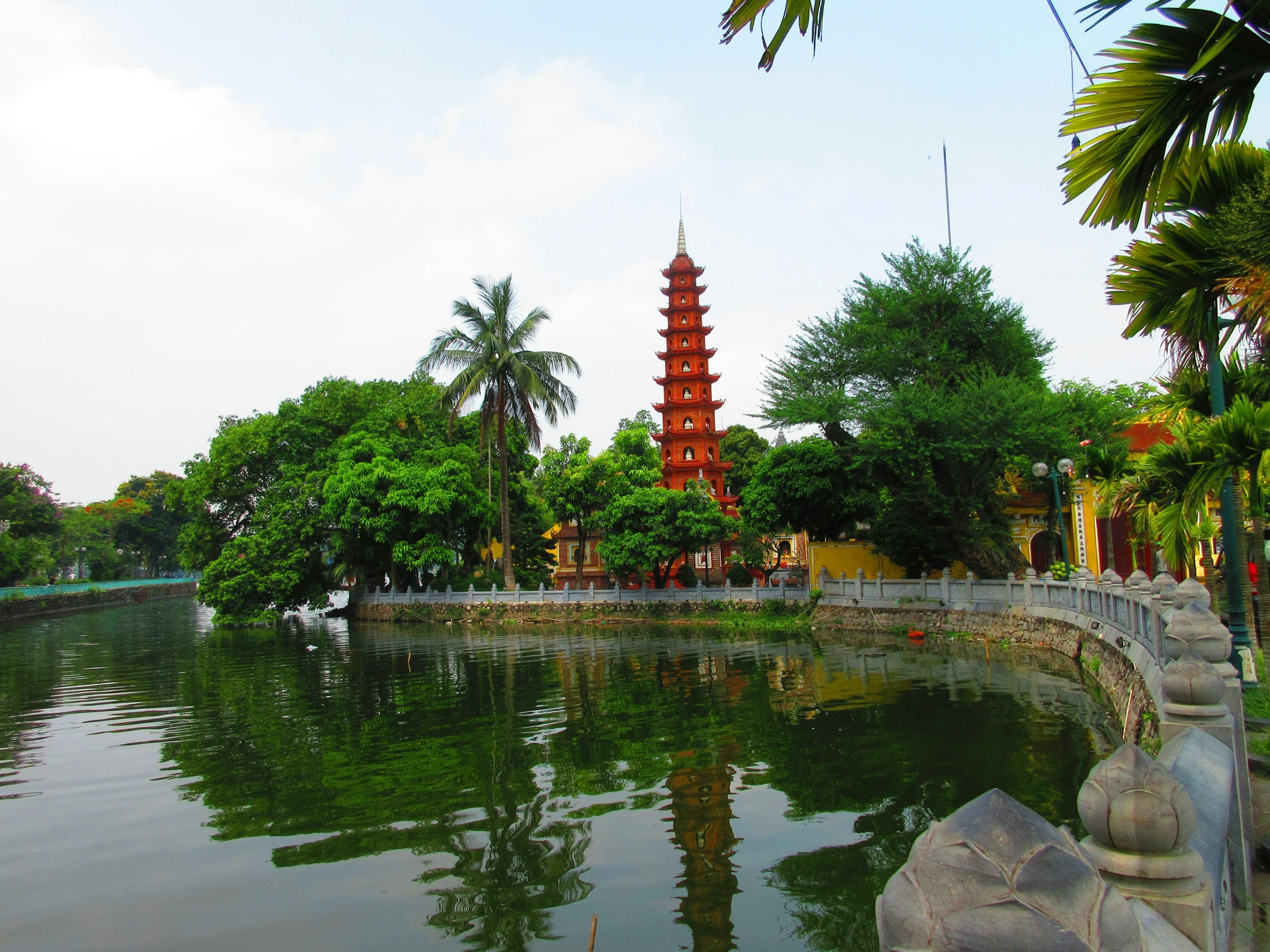 a pond in a chinese garden next to a large pagoda