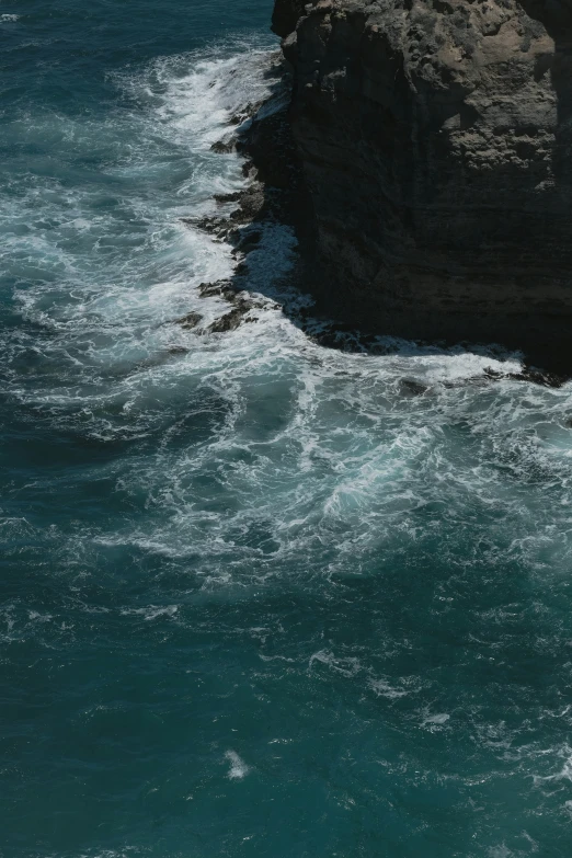 a person in a black wetsuit surfing on a large body of water