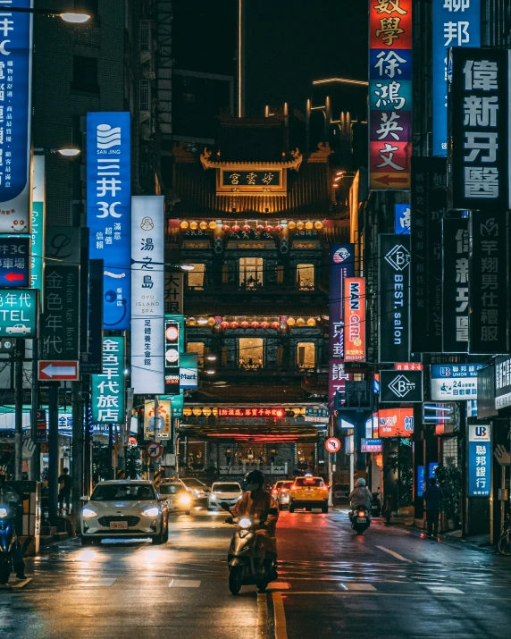 people and cars in the streets at night