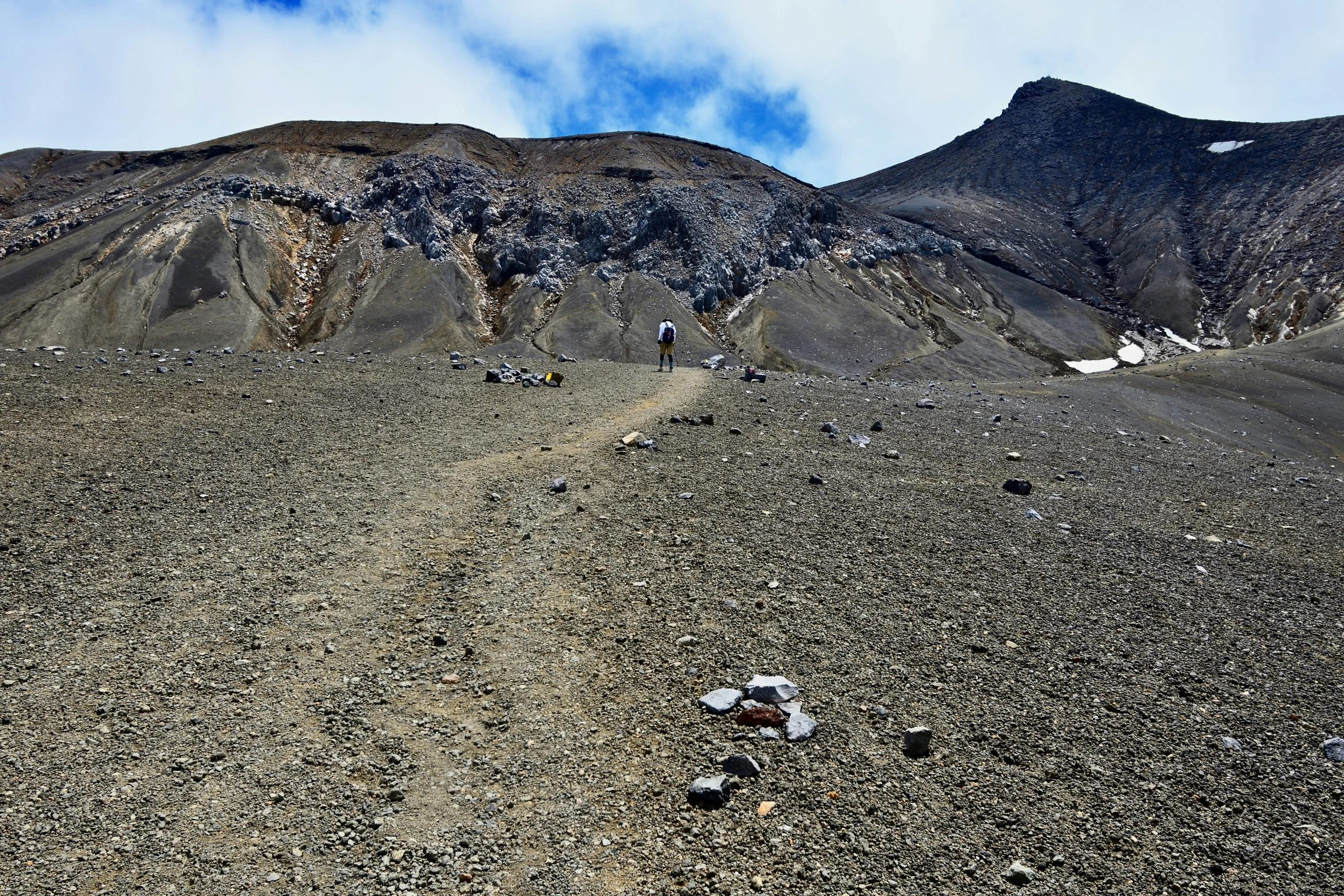 a view of a dirt road leading through a mountainous area