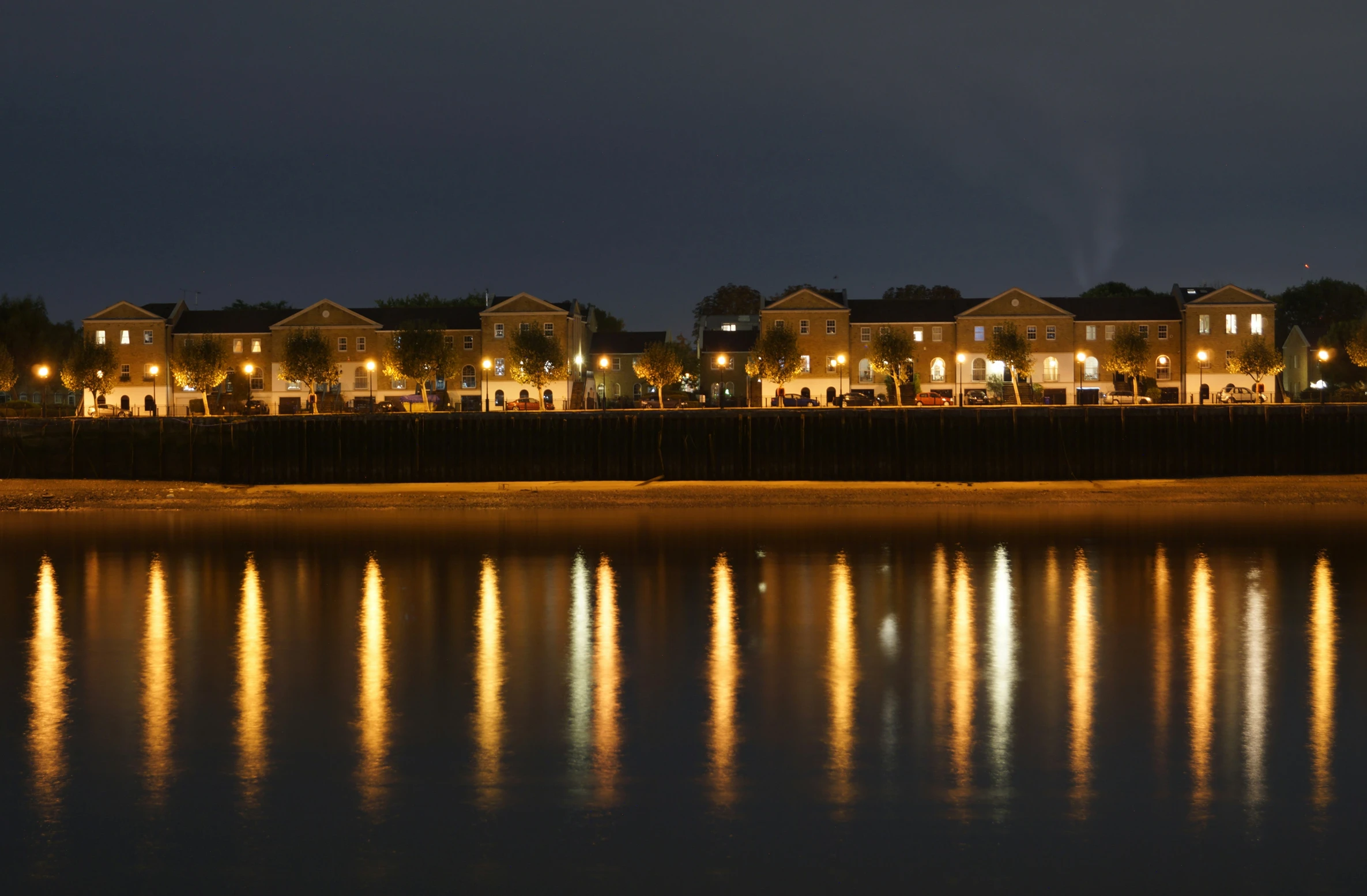 a row of houses beside the water at night