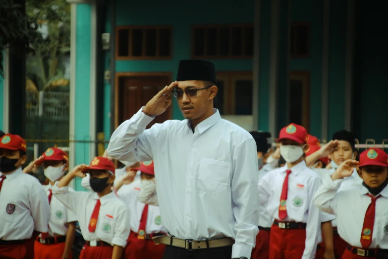 a man saluting to his school class of students