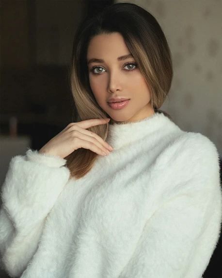 a woman with brown hair in a white sweater