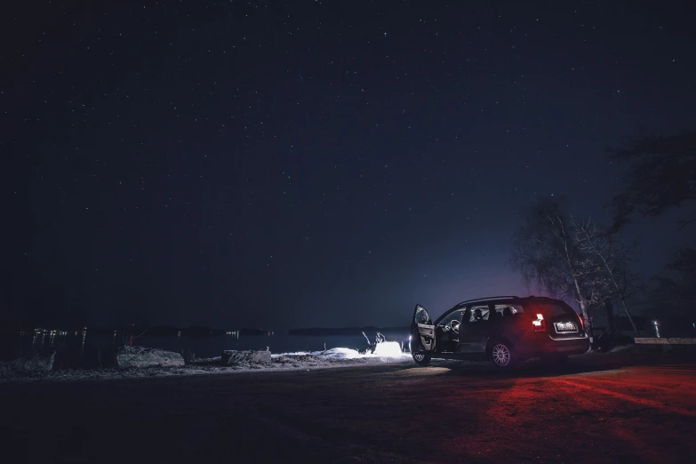 a car is parked under stars in the dark
