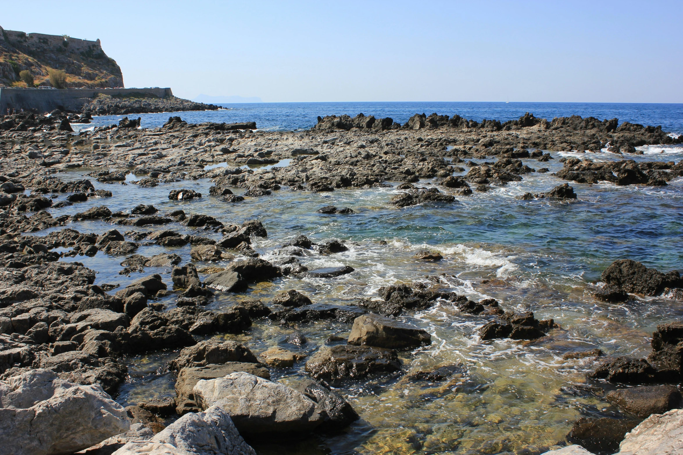 a rocky beach with some green and gray rocks