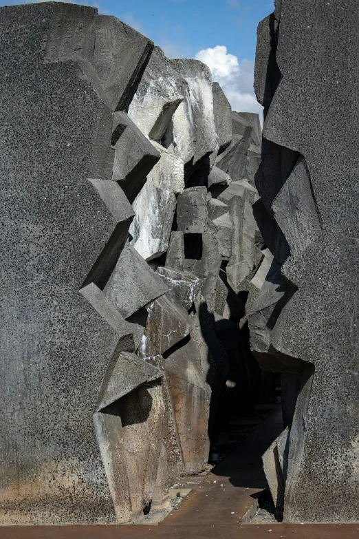 the entrance to a cave carved with large rocks