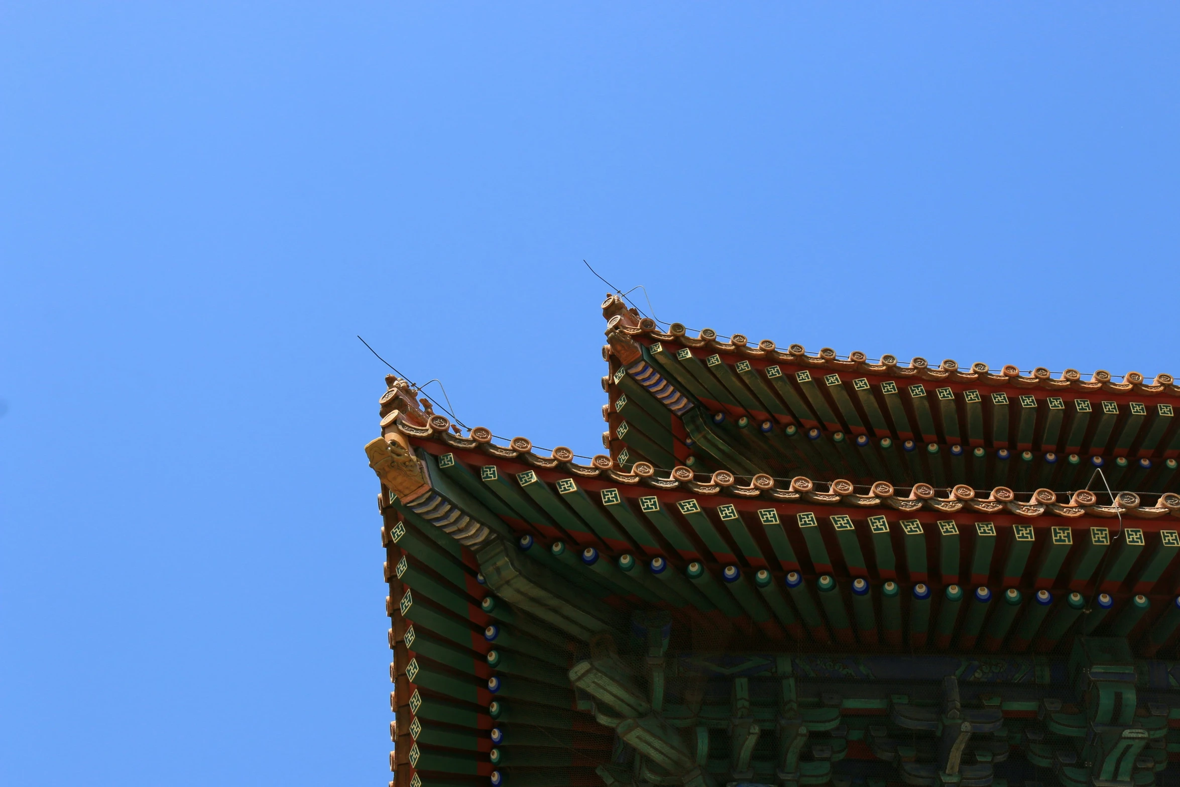 two buildings under a clear blue sky with birds in the background