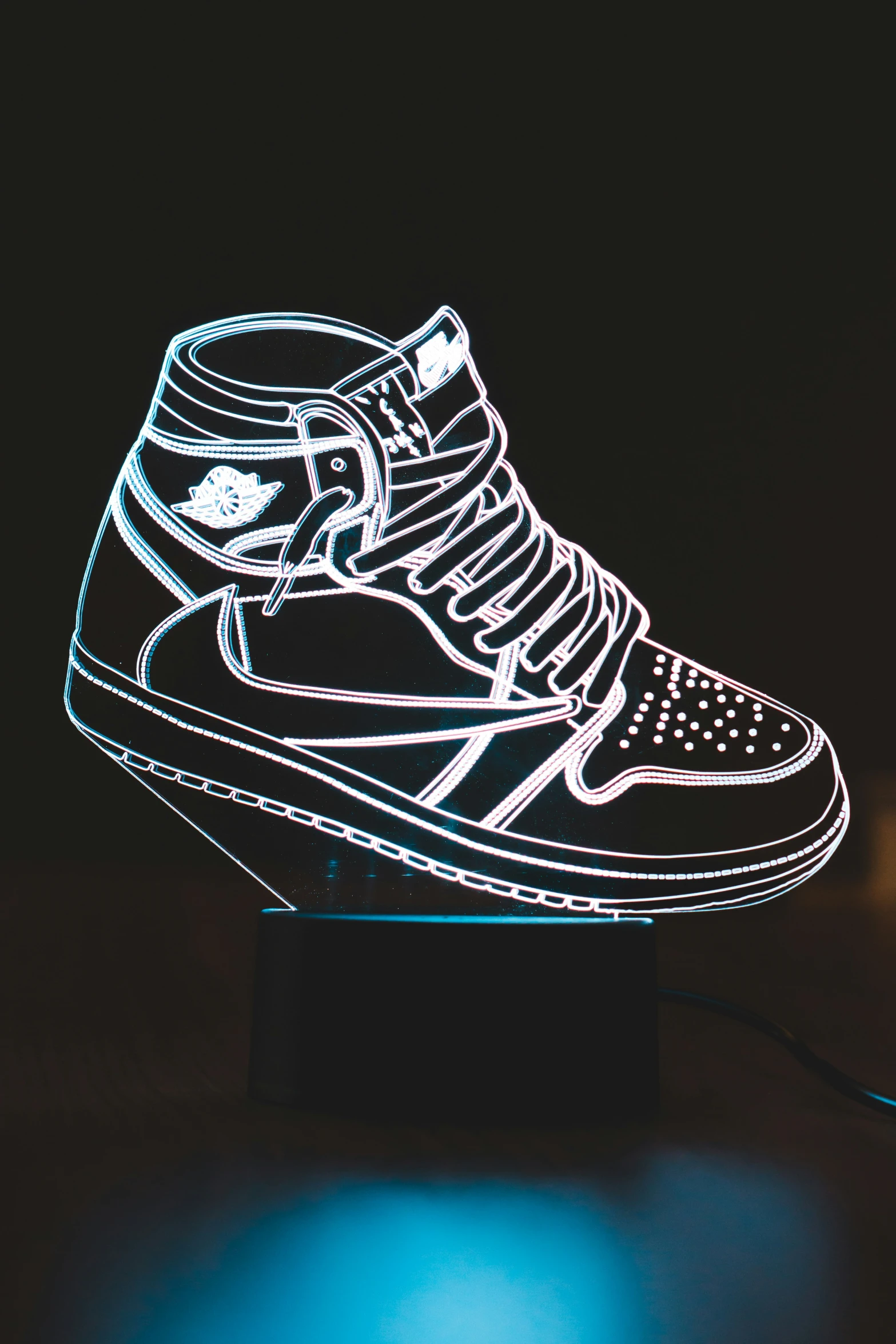 an illuminated shoe sits on a stand