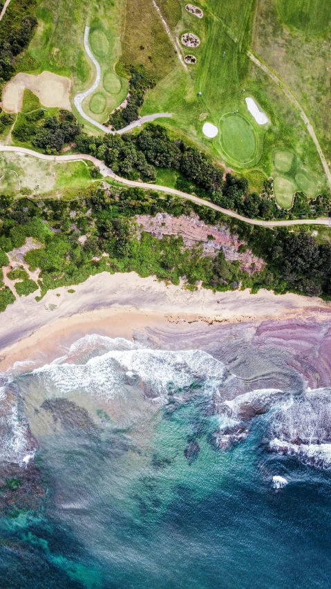 an aerial view of a golf course by the ocean