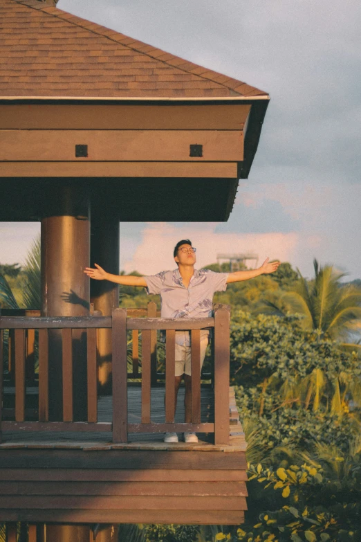 there is a man standing on the porch next to a building