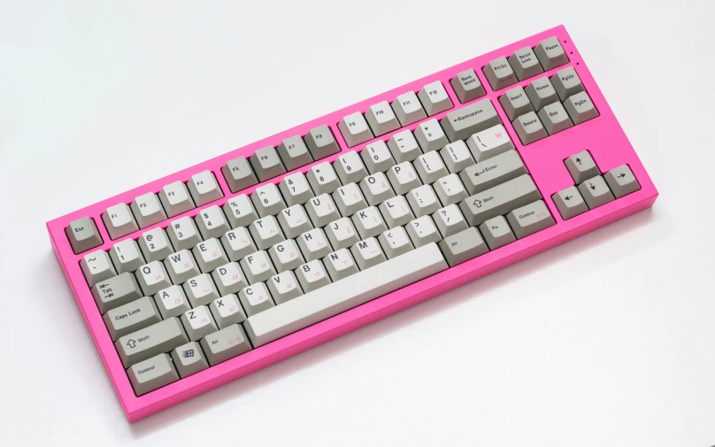 a pink computer keyboard sitting on a white table