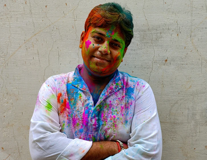 a man that has his arms folded wearing colorful clothing