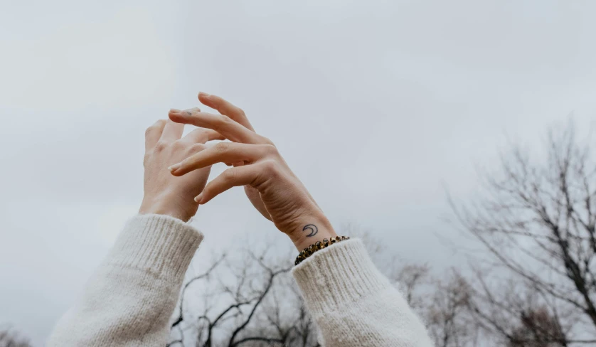 a close up s of two hands reaching out in the sky