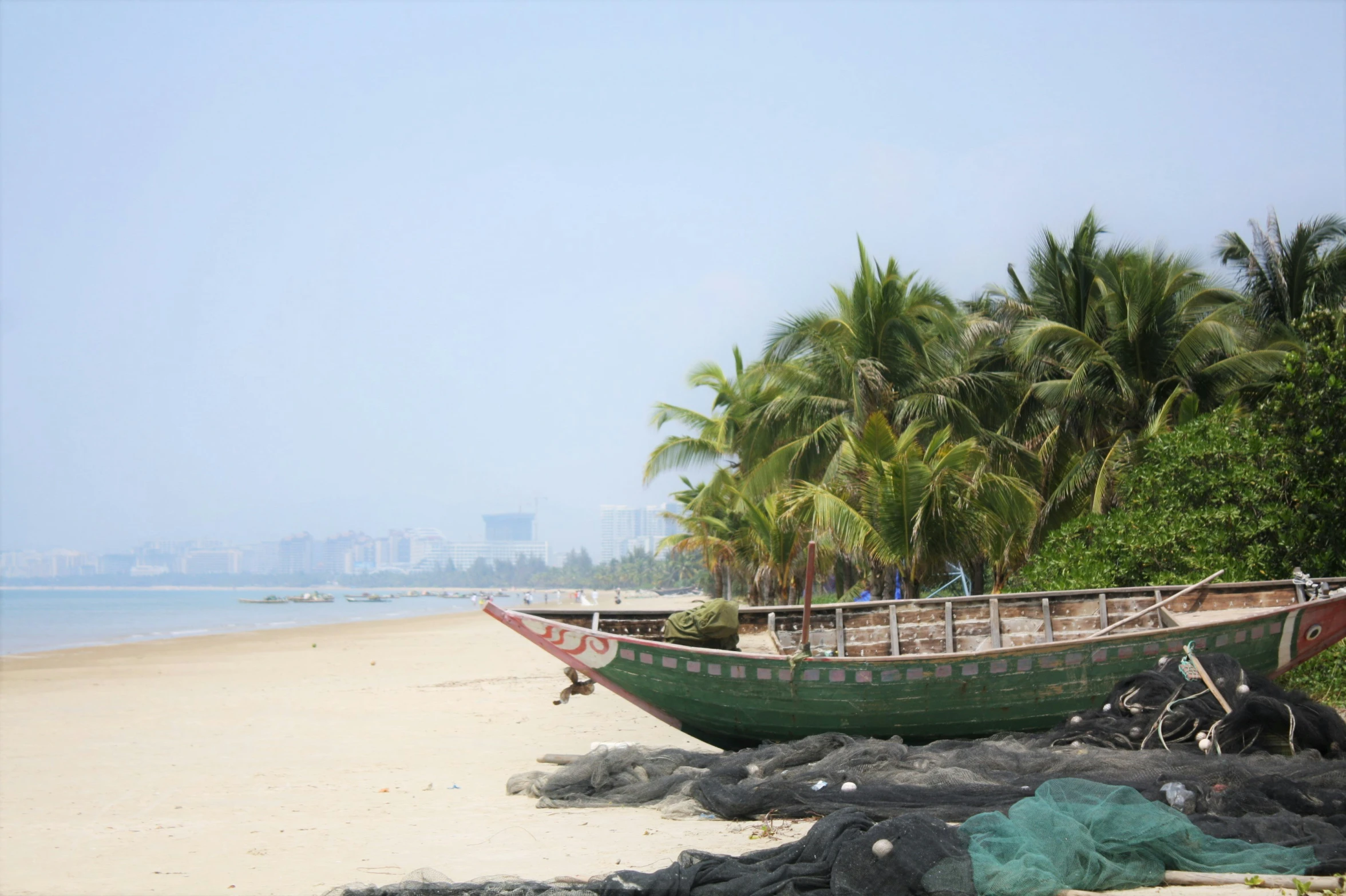 an old boat sits on the shore by the ocean