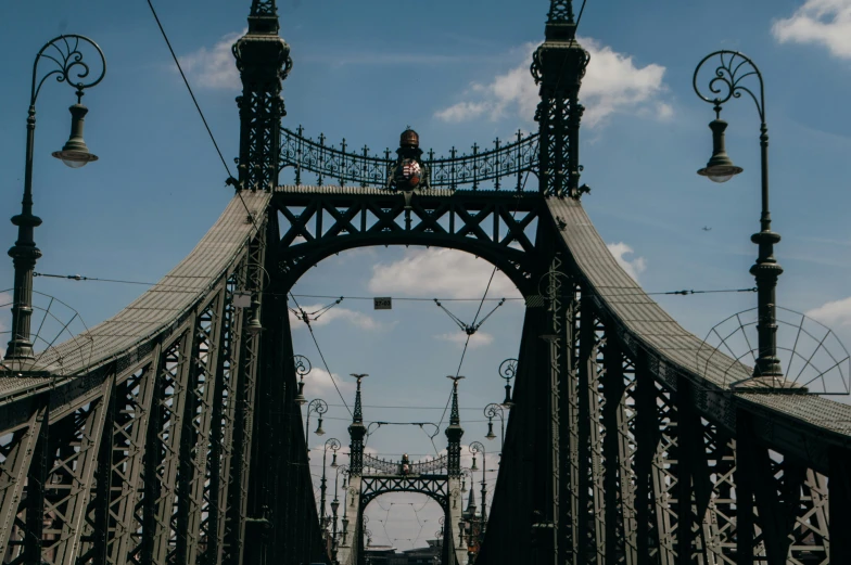 a man standing on a bridge with traffic on the bridge