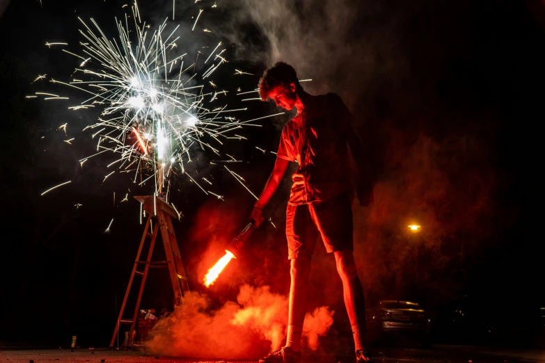 a man is standing with a shovel near fireworks