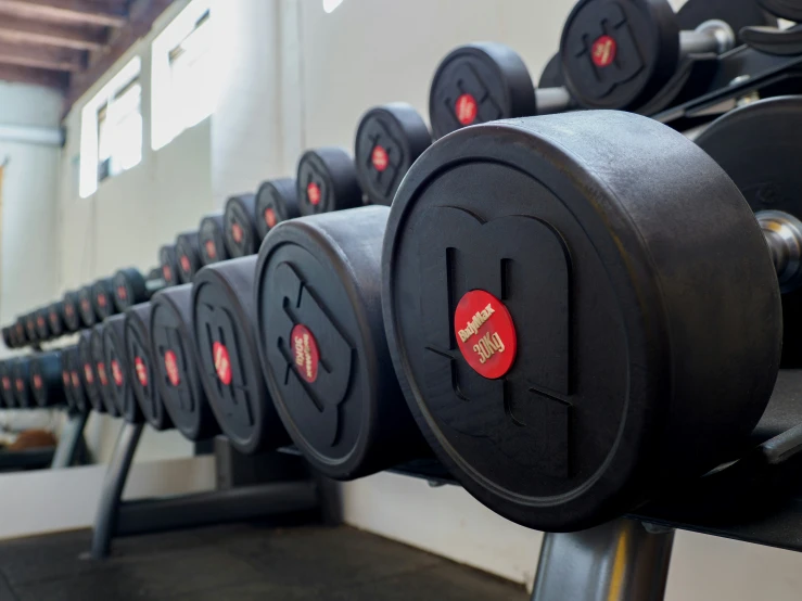 dumbs are lined up against the wall in a gym