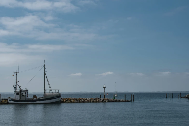 the old boat is docked on the pier by the water