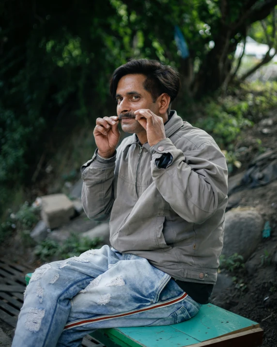 a man sitting on a bench holding a cigarette