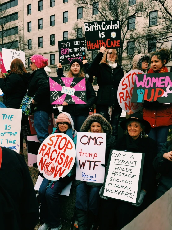 several protesters with protest signs and signs standing on steps