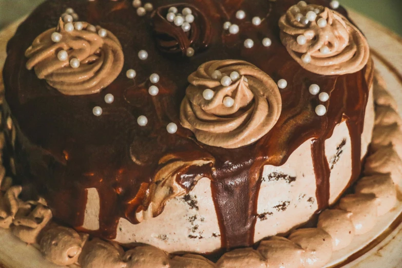 a cake with chocolate frosting and frosting, drizzled and topped with candy