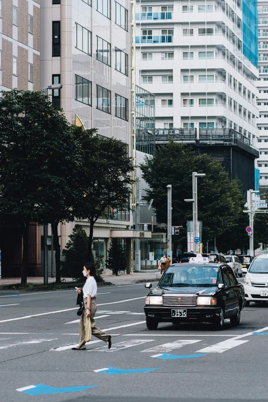 a car and a bike and a pedestrian crossing the street