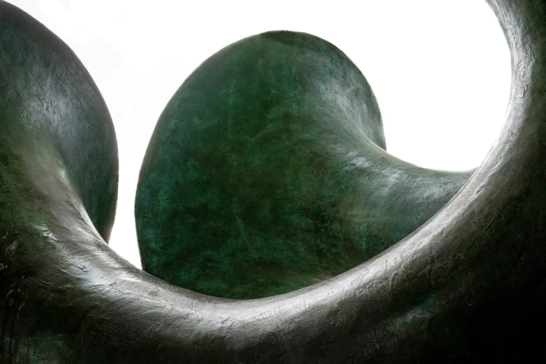 an abstract piece with dark green colors and rounded body