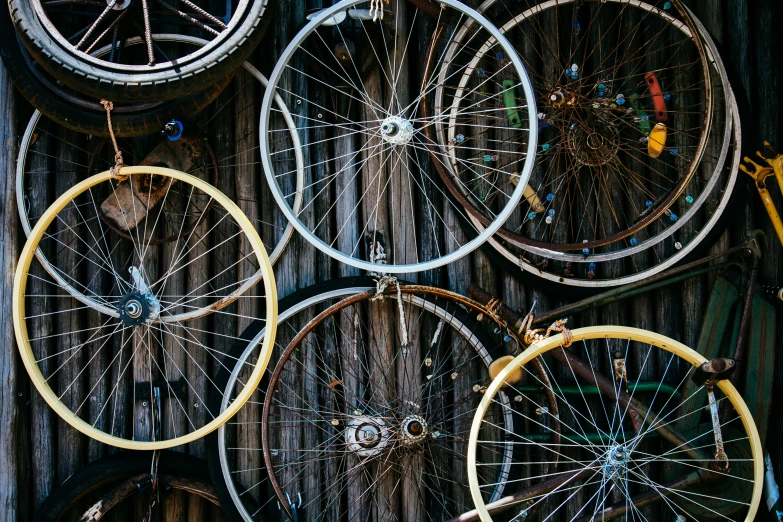 several spokes and spokes are hanging on a fence