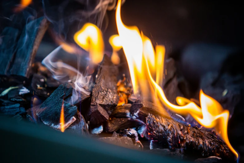 fire in a fireplace with bright flames and black background