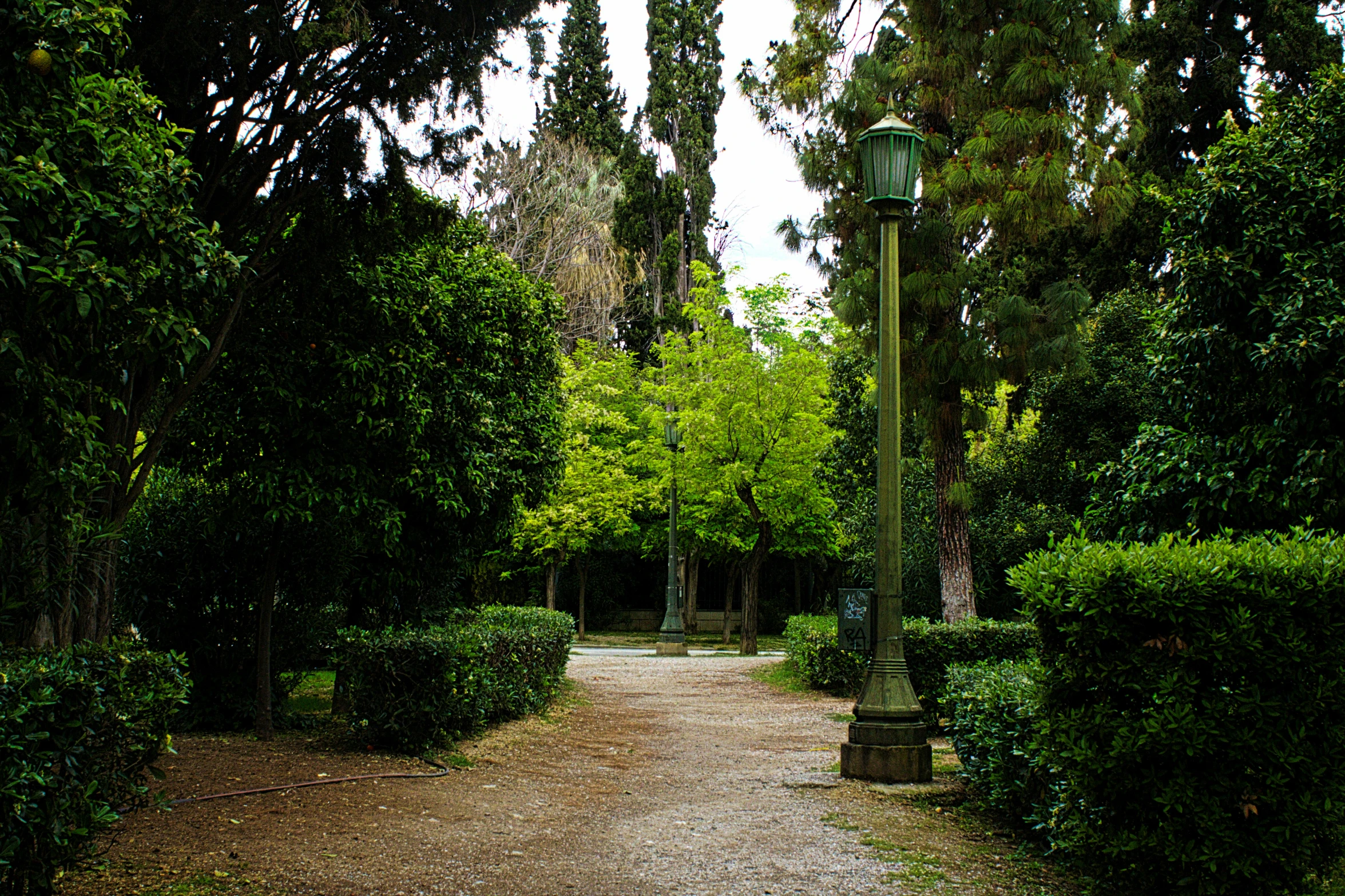 a narrow pathway with a clock at the end