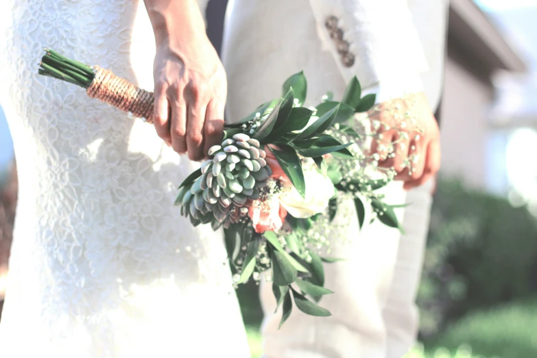 the bride and groom hold bouquets of flowers on their wedding day