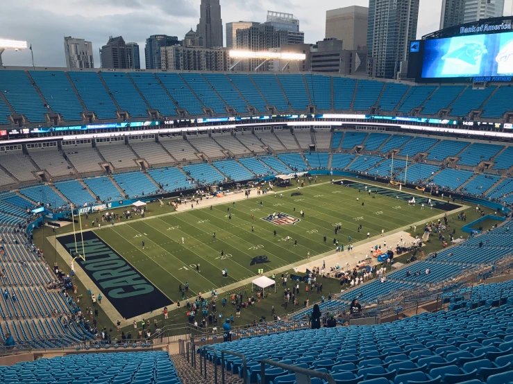 an empty football stadium with blue seats and players