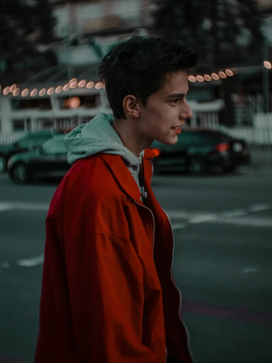 a man walking down the street while wearing a red jacket