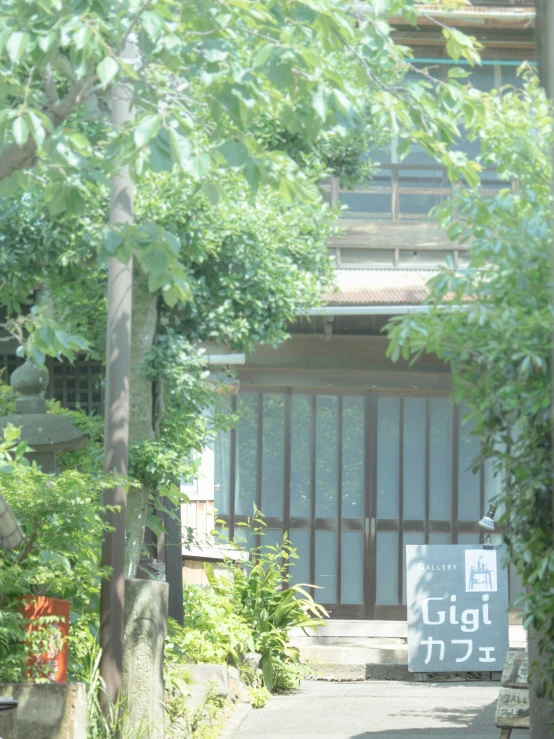 a street sign on the edge of a path under trees