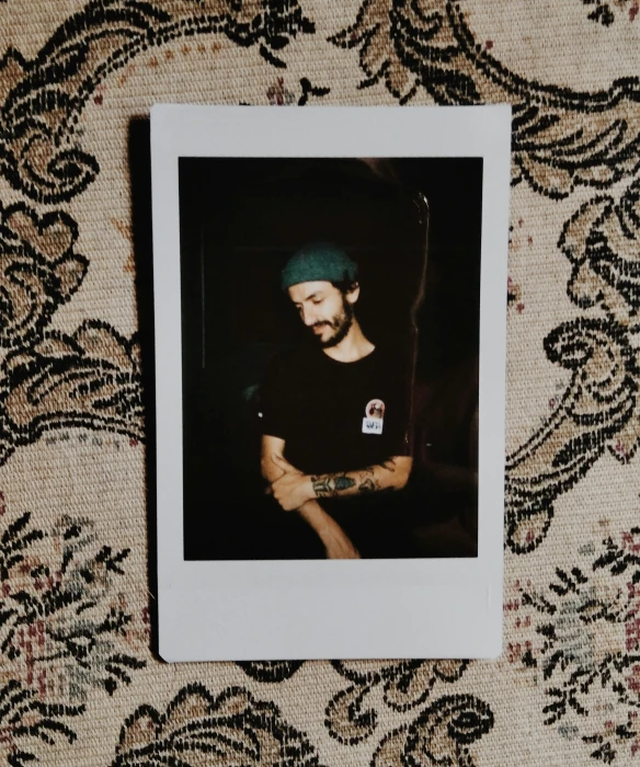 a black and white po of a man wearing a beanie and staring to the side