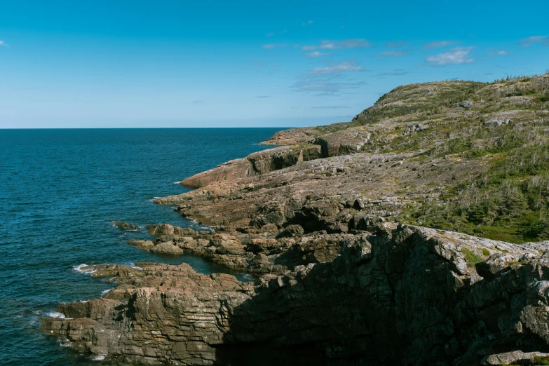 an ocean view with the rocks in the foreground and water in the back ground