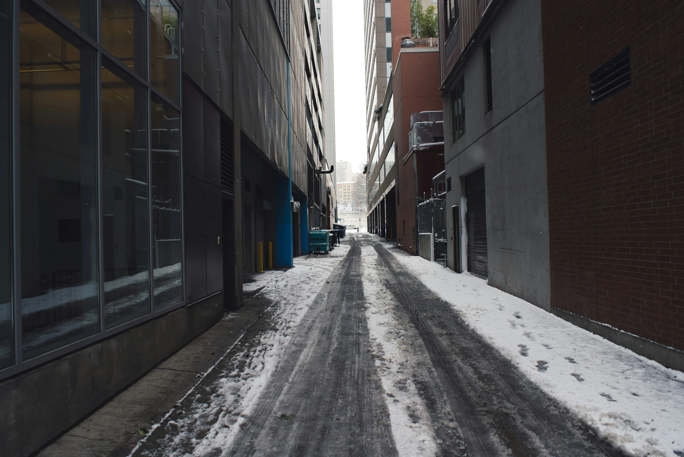a city street covered in a layer of snow next to tall buildings