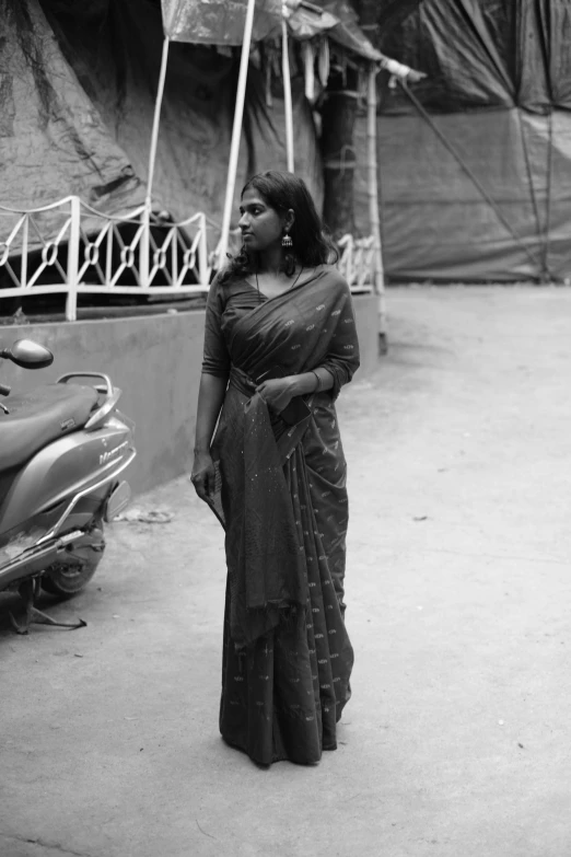 an older woman wearing a sari on a street