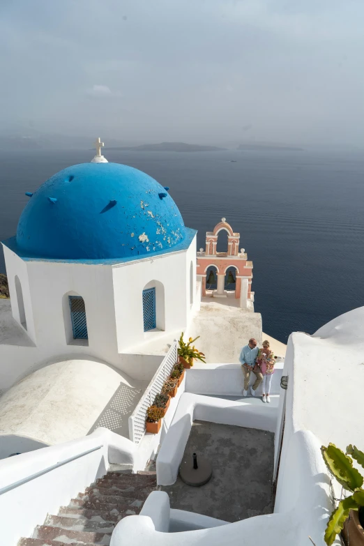 the blue dome and white buildings overlook the ocean