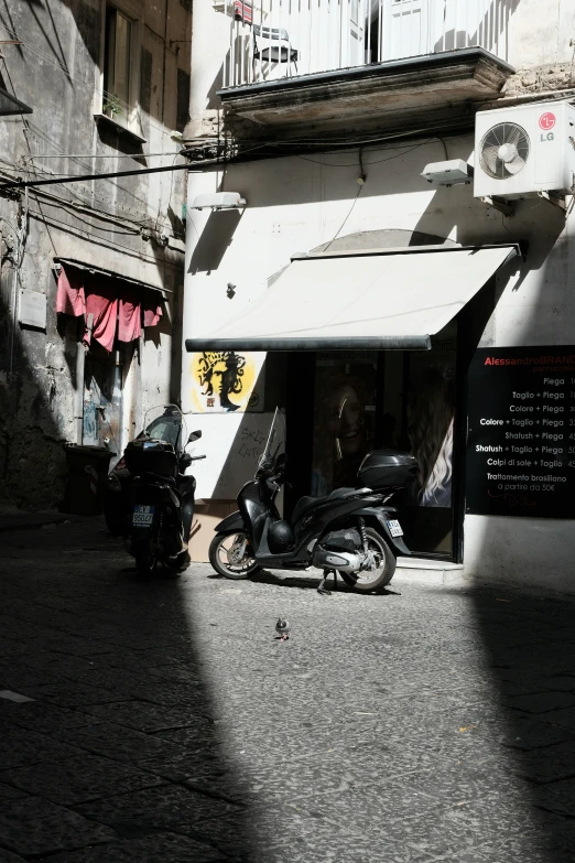 two motorcycles parked under a white awning