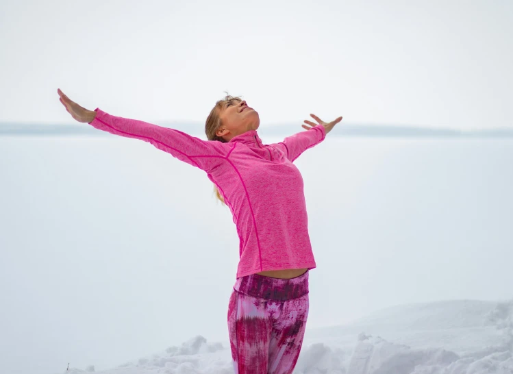 a woman standing on the top of a snow covered slope